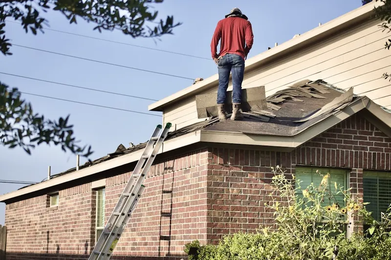Professional roofer working on a residential roof in Satsuma
